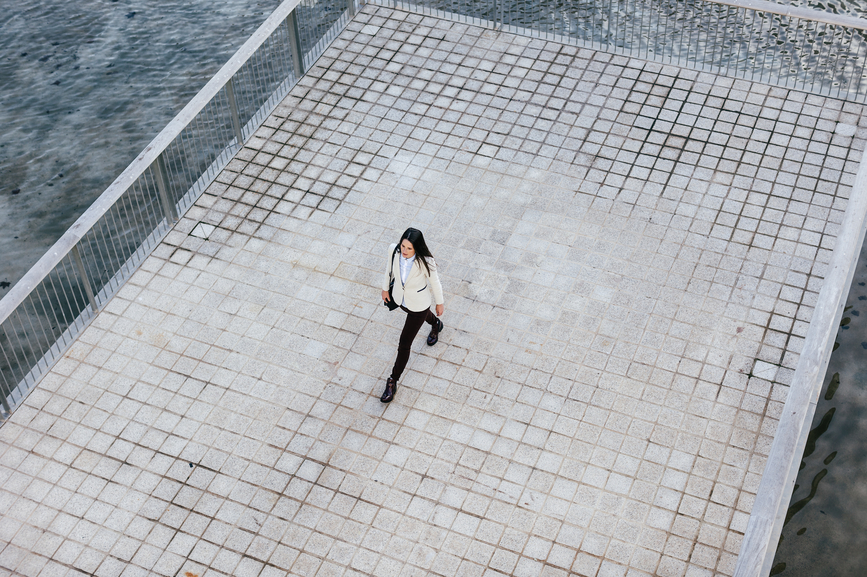 Woman standing outside placed below a satellite + zephr cell phone network icon with the text '< 1 meter accuracy' above her head